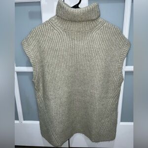 Sage green knit sweater with open back.